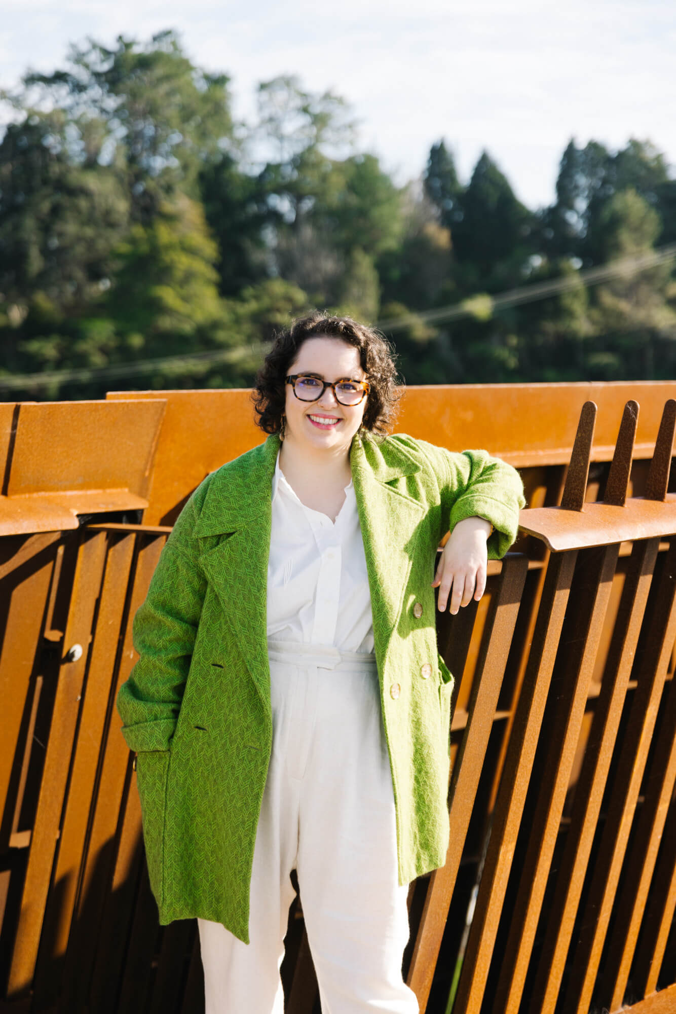Louise leaning against the side of the new bridge, Te Ara Pekapeka